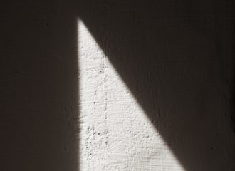 Beam of light against cement wall. Photo by Callum Wale on Unsplash